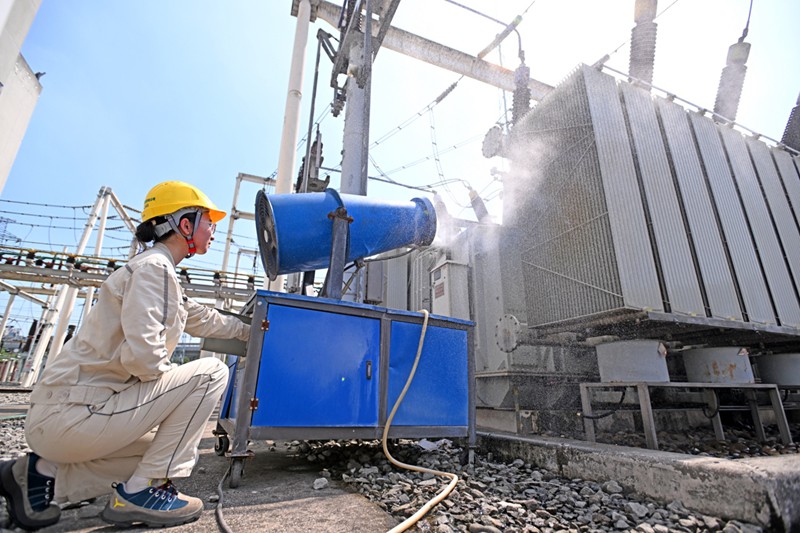 高溫天氣下，國網重慶市北供電公司運維人員在220千伏大竹林變電站用水炮對變壓器進行降溫。向江微攝