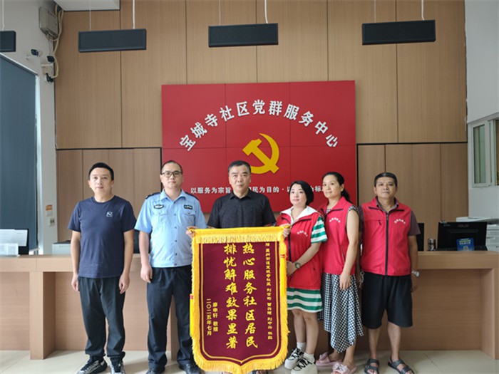 居民廖先生為寶城寺社區民警、網格員送錦旗致謝。通訊員 王軒 攝