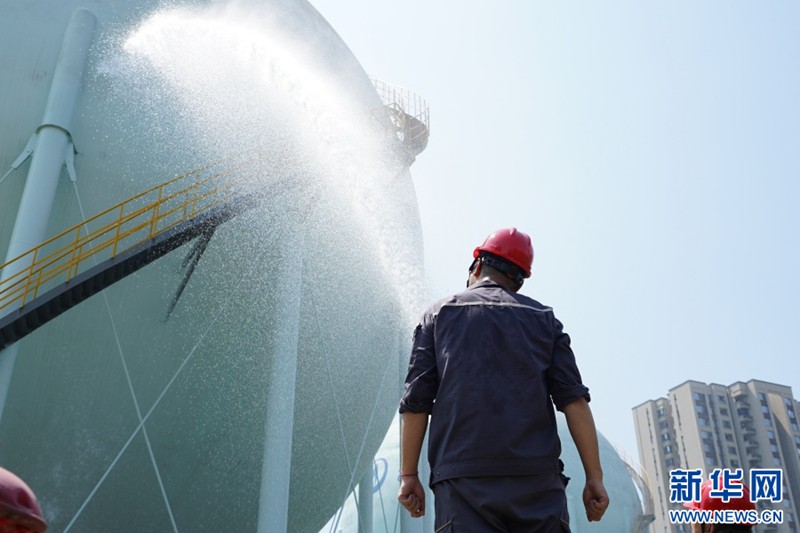 工作人員對球罐進行噴水降溫。新華網 彭浩然 攝