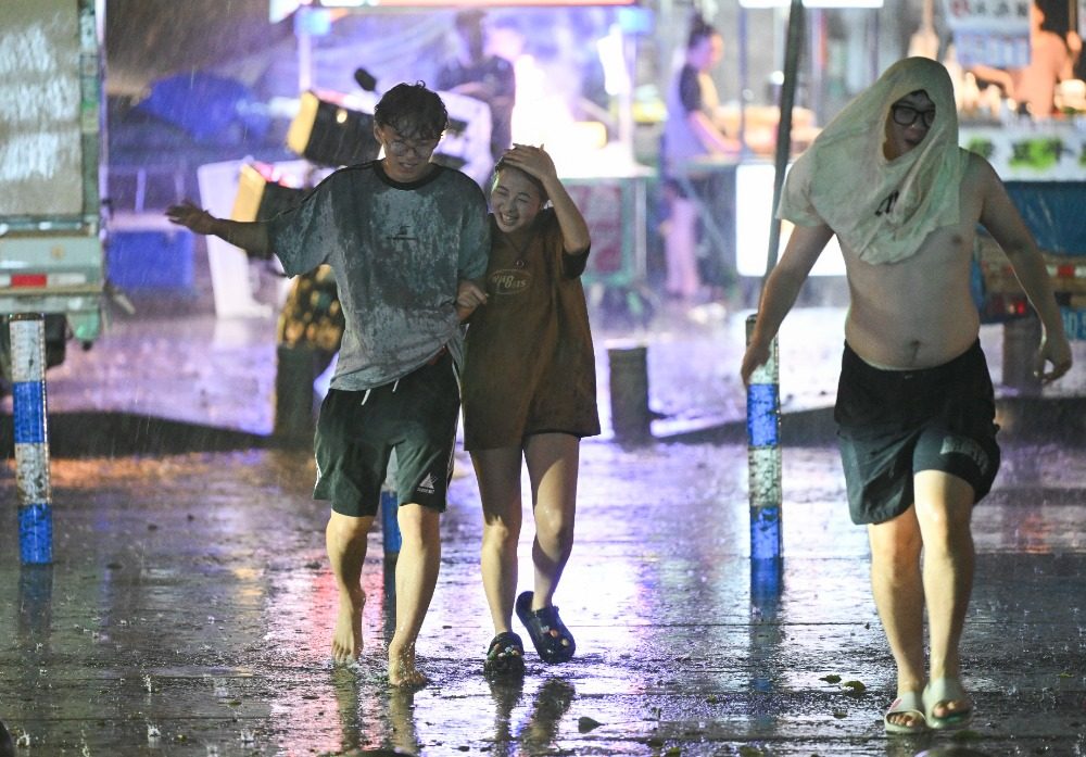 8月6日晚，南岸區水云路，市民開心地行走在暴雨中。記者 謝智強 攝