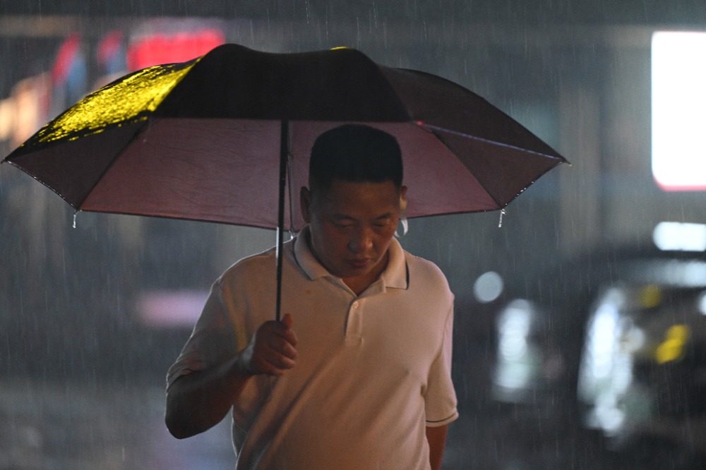 8月6日晚，南岸區水云路，市民行走在暴雨中。記者 謝智強 攝