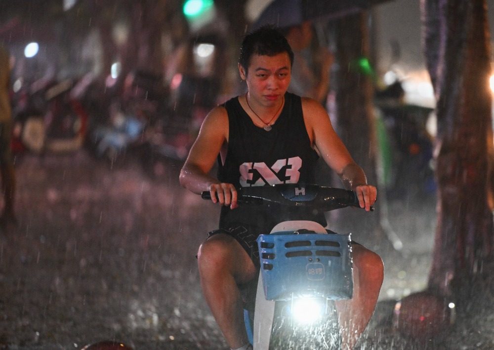 8月6日晚，南岸區水云路，市民在暴雨中騎行。記者 謝智強 攝