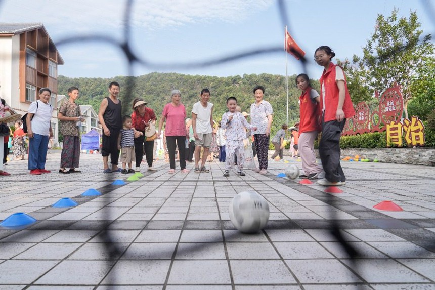 8月8日，在北碚區澄江鎮北泉村舉行的北碚區全民健身日主題活動現場，村民們在參加定點射門趣味運動項目。特約攝影 秦廷富