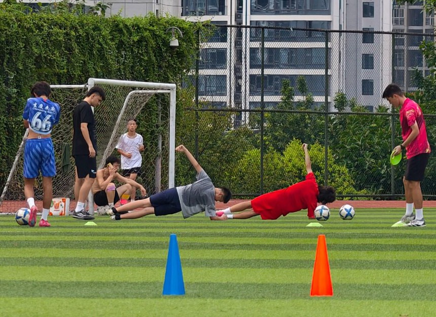 2025年8月8日，江北區石子山體育場，年輕人在操場上訓練足球。記者 崔力 攝