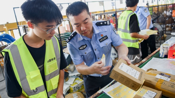 民警為快遞貼上反詐宣傳小貼紙。南岸區公安分局供圖