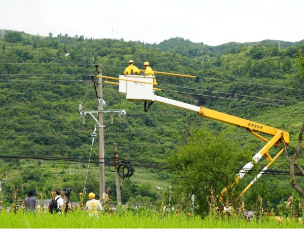 媒體記者在綦江區東溪鎮拍攝供電員工引流線搭接工作。袁巧攝