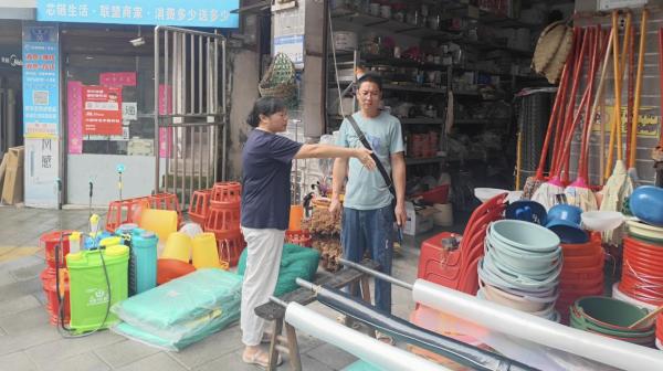 張欽庭規勸占道經營的攤主。東溫泉鎮供圖