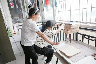 李遇梅攥著女兒僵硬的身體不斷練習下蹲。楊青攝