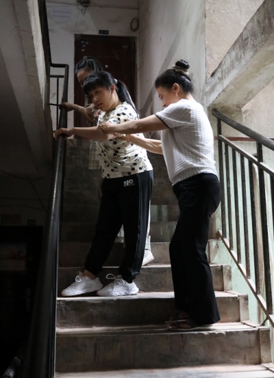 李遇梅正扶著女兒下樓。趙英如攝