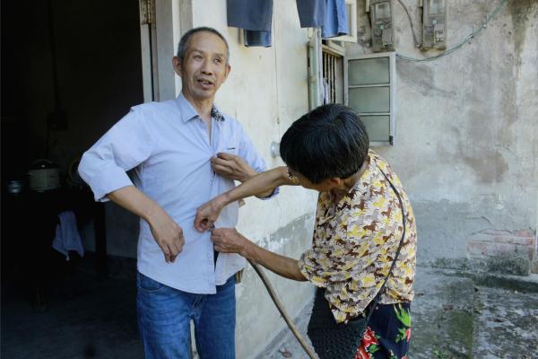 銀齡志愿者為老人整理衣服。鄒冰倩攝