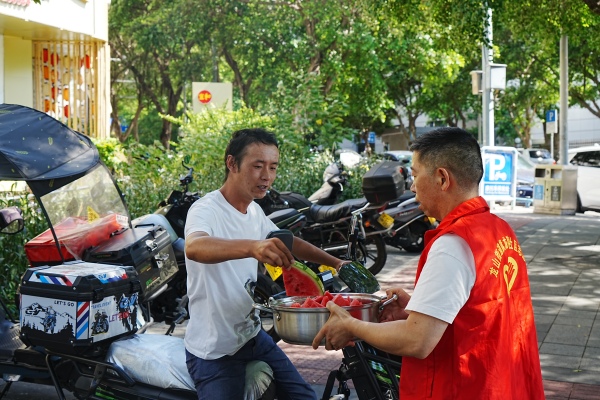 社區志愿服務隊為新就業群體送清涼物資。龍山街道供圖