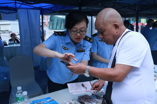 現場工作人員為市民講解安全用藥注意事項。重慶市藥品監督管理局供圖