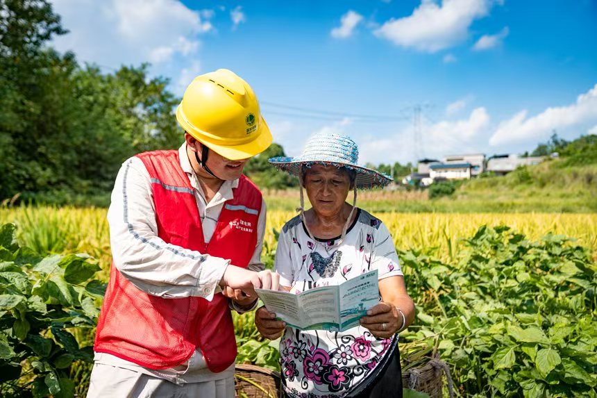 電力人員向村民介紹安全用電知識。國網永川供電公司供圖