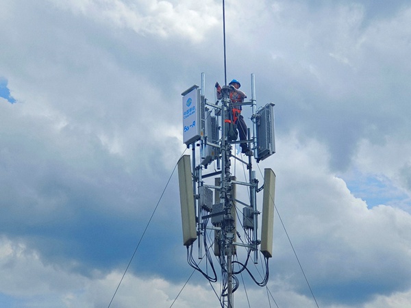 作業人員登上通信桅桿塔，進行5G-A通感一體基站安裝作業。重慶移動供圖