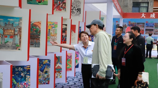 與會人員在實驗二小參觀書法作品展、社團成果展。城口縣教委供圖
