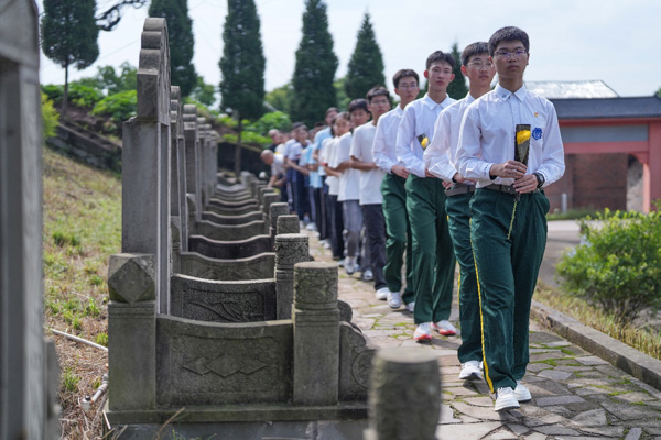 現場師生、黨員干部依次向周極明等烈士墓敬獻花。周久淞攝