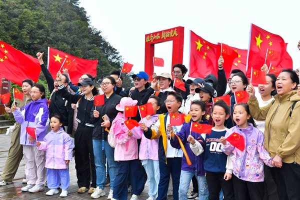 游客們揮舞國旗表達對祖國的美好祝愿。景區供圖