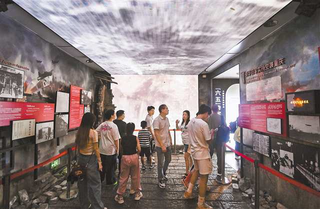 10月1日，渝中區重慶大轟炸“六五”隧道慘案史實展館，游客們帶著孩子正在了解抗戰歷史。記者 鄭宇 攝/視覺重慶