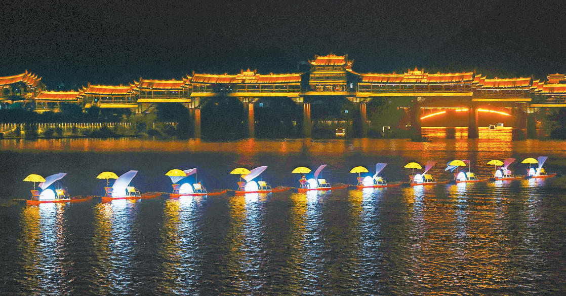 10月5日，黔江區濯水古鎮阿蓬江上，演藝人員為游客表演鵲舟游。  　　國慶、中秋假日期間，黔江區濯水古鎮開展夜游阿蓬江活動，在阿蓬江上表演火壺、打鐵花、花船巡游、水上飛人等項目，演繹了一場夜幕下的水上文化盛宴，吸引了眾多游客前往觀賞。特約攝影 楊敏/視覺重慶