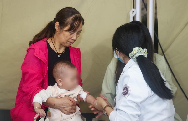 不少居民帶著孩子來到現場，體驗小兒推拿。曾英豪攝