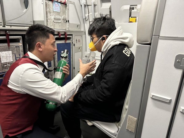 機上乘務員向旅客實施吸氧救助。重慶航空供圖