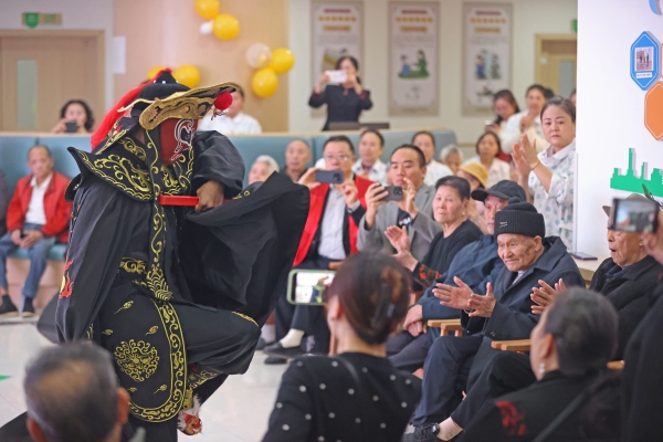 志愿服務隊正在為老人們表演川劇變臉。趙勇攝