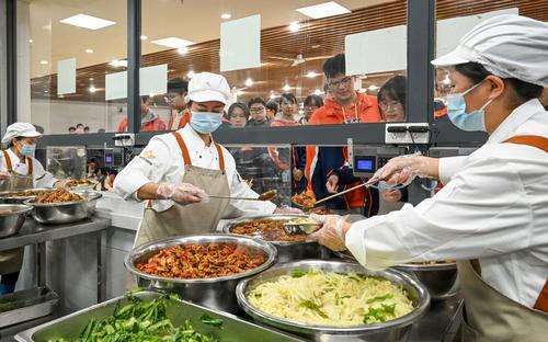 10月29日，位于兩江新區的兩江育才中學校，工作人員在食堂售賣廳為學生們盛飯菜。記者 張錦輝 攝/視覺重慶