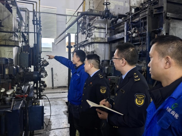 綦江區應急管理局的執法人員在綦江永躍齒輪有限公司察看設備。楊晨攝