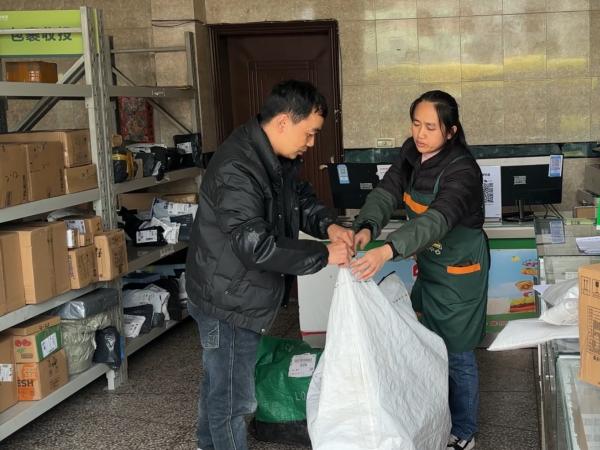 公交車司機將貨物交接給雙壩村綜合便民服務站人員。渝運集團萬盛分公司供圖